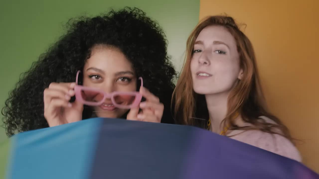 Download Free Stock Video Two Girls Having Fun With A Colorful Umbrella Live Wallpaper