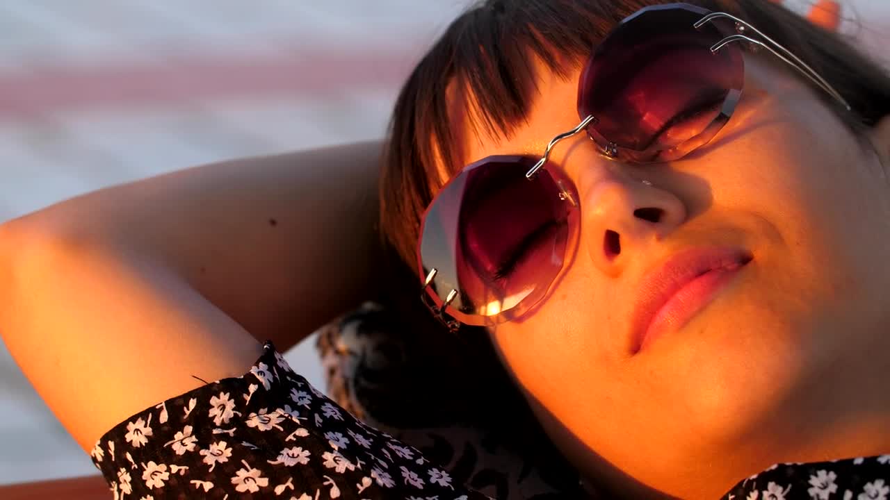 Download Free Stock Video Young Woman With Glasses Resting Lying In The Sun Live Wallpaper