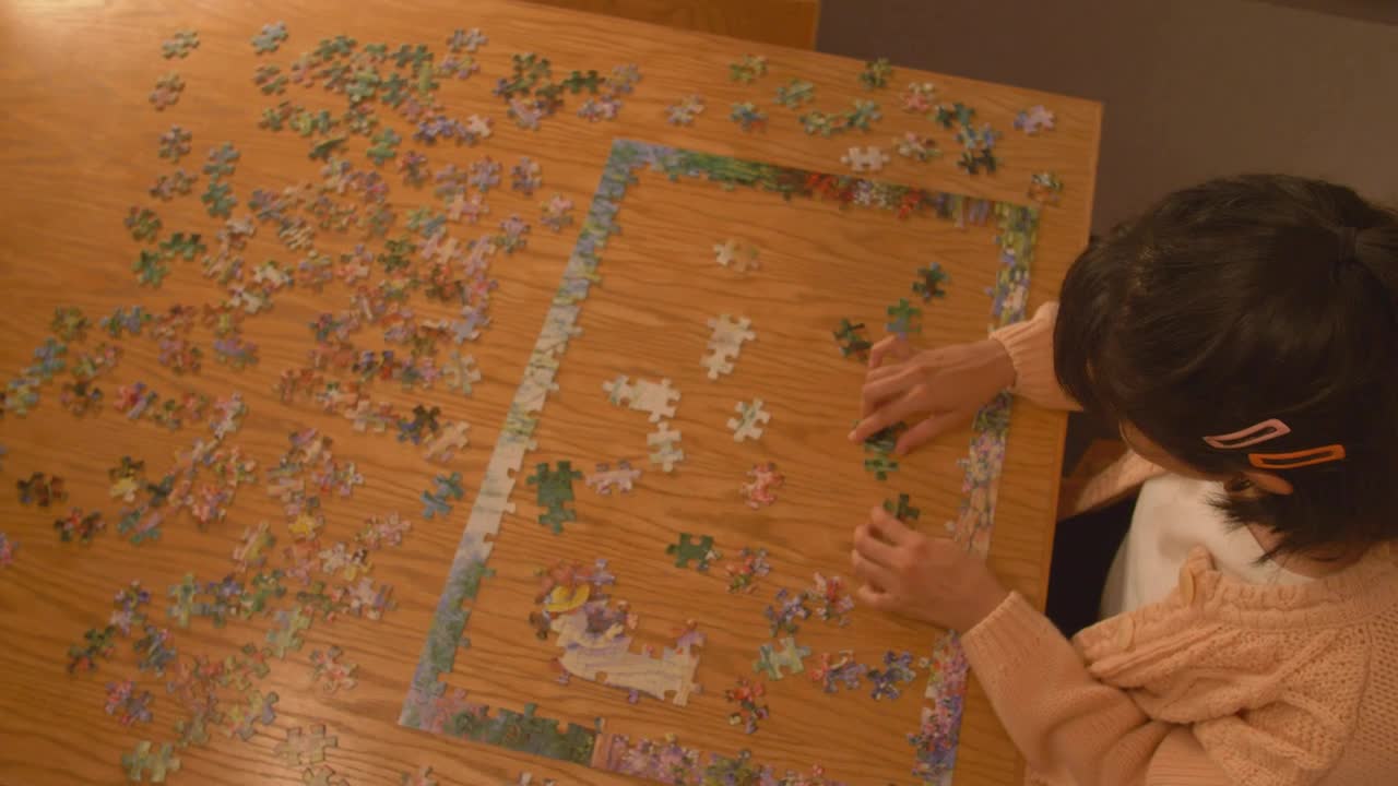 Download Free Stock Video Young Woman Putting Together A Puzzle Live Wallpaper