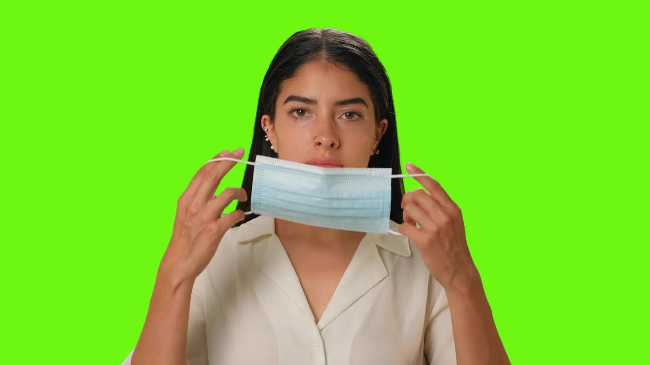 Download Free Stock Video Young Woman Putting On A Mask On A Green Background Live Wallpaper