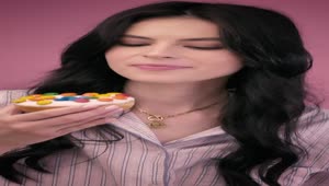 Free Stock Video Young Woman Biting A Donut On A Pink Background Live Wallpaper