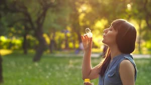Free Stock Video Young Woman Blowing Bubbles In A Park At Sunset Live Wallpaper
