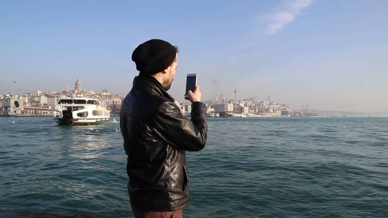 Download Free Stock Video Young Man Taking Photos On A Sunny Shore Live Wallpaper