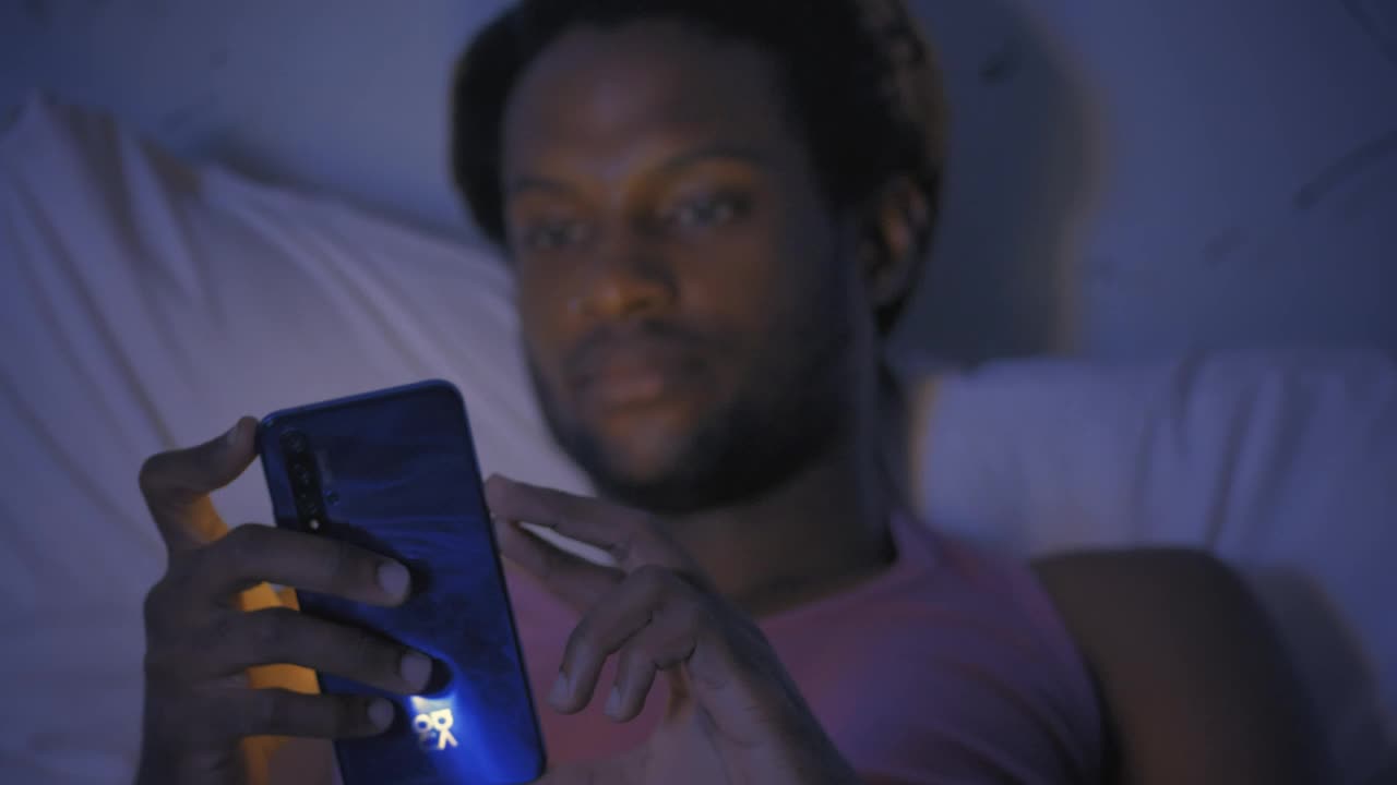 Download Free Stock Video Young Man Lying On His Bed Checking His Smartphone Live Wallpaper