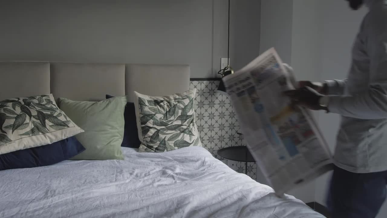 Download Free Stock Video Young Man Laying On A Bed Reading The Newspaper Live Wallpaper