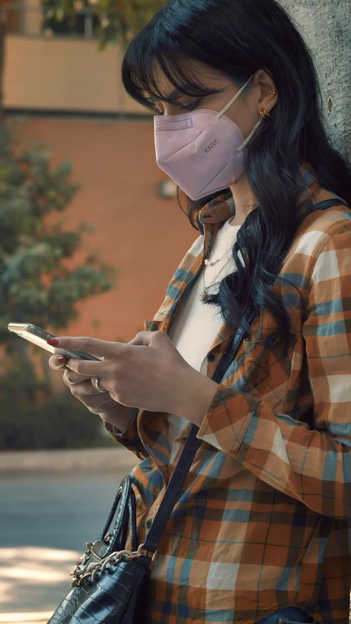 Download Free Stock Video Woman With A Face Mask Texting On The Phone Live Wallpaper