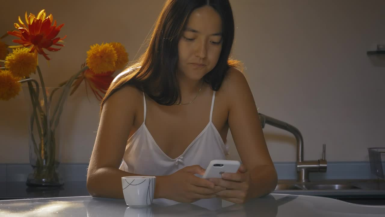 Download Free Stock Video Woman Using Her Cell Phone While Drinking Morning Coffee Live Wallpaper