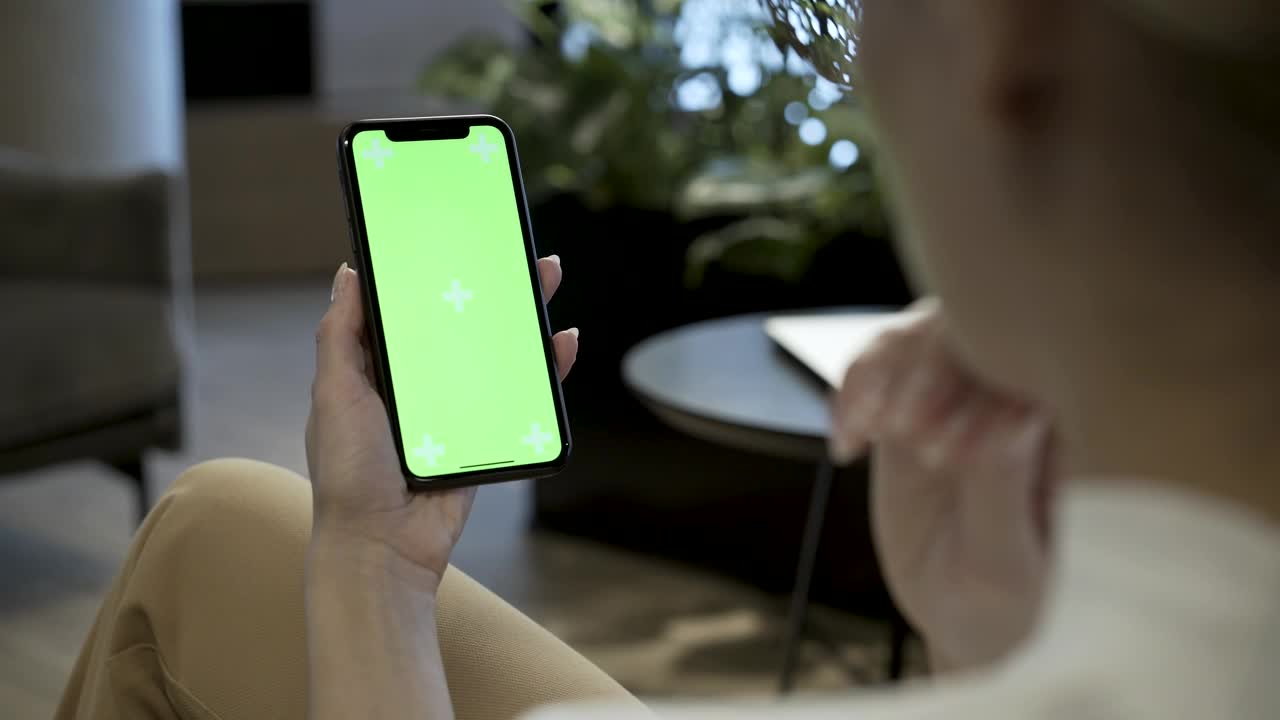 Download Free Stock Video Woman Holding Mobile Phone With A Green Screen Live Wallpaper