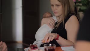 Free Stock Video Woman Eating Breakfast While Holding Her Baby Live Wallpaper