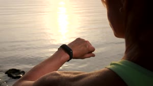 Free Stock Video Woman Checks Her Smart Watch While Watching Sunset Live Wallpaper
