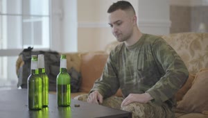   Stock Footage Upset Army Veteran Sits On Sofa Drinking Beer Live Wallpaper