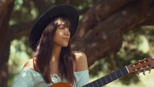 Stock Footage Woman Sits Outdoors Holding A Guitar Live Wallpaper Free
