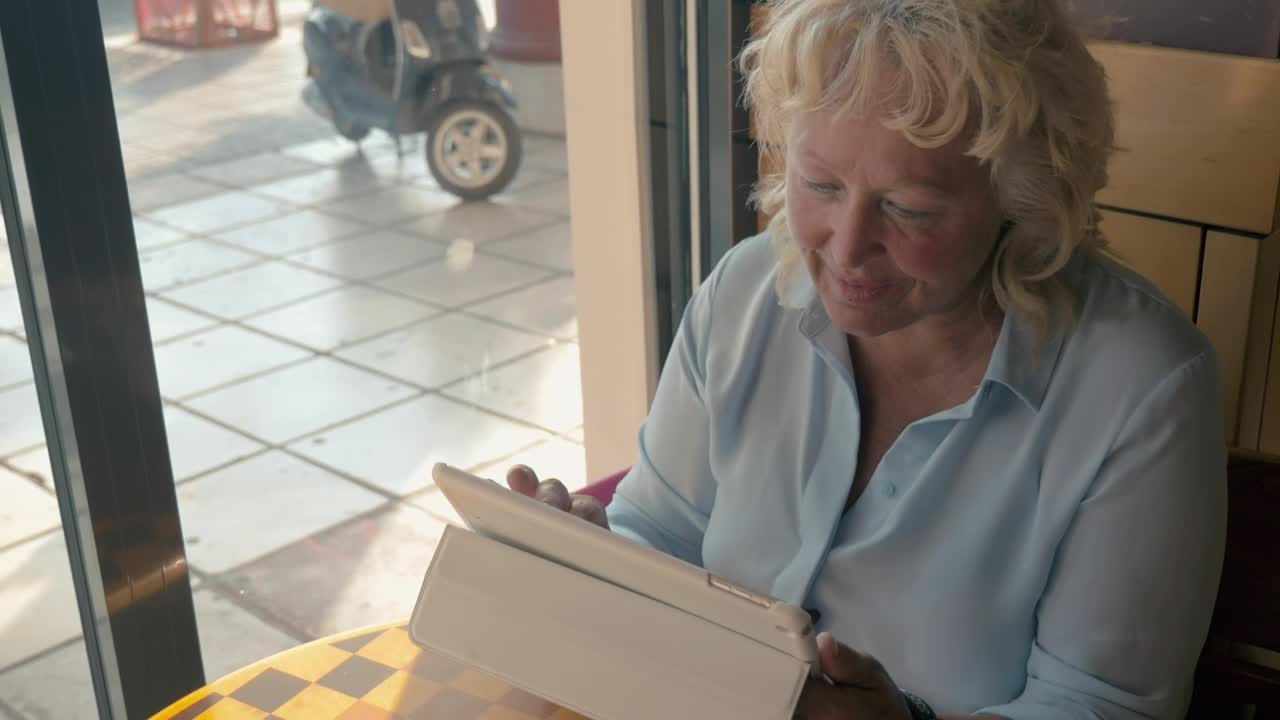Download Stock Footage Woman Using A Tablet From A City Cafe Live Wallpaper Free