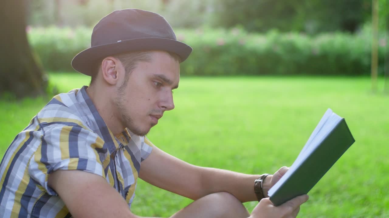 Download Stock Footage Young Man Reading A Book In The Park Live Wallpaper Free