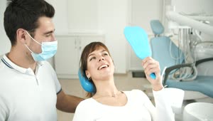 Stock Footage Woman Looks At Teeth In Dentist Office Mirror Live Wallpaper Free