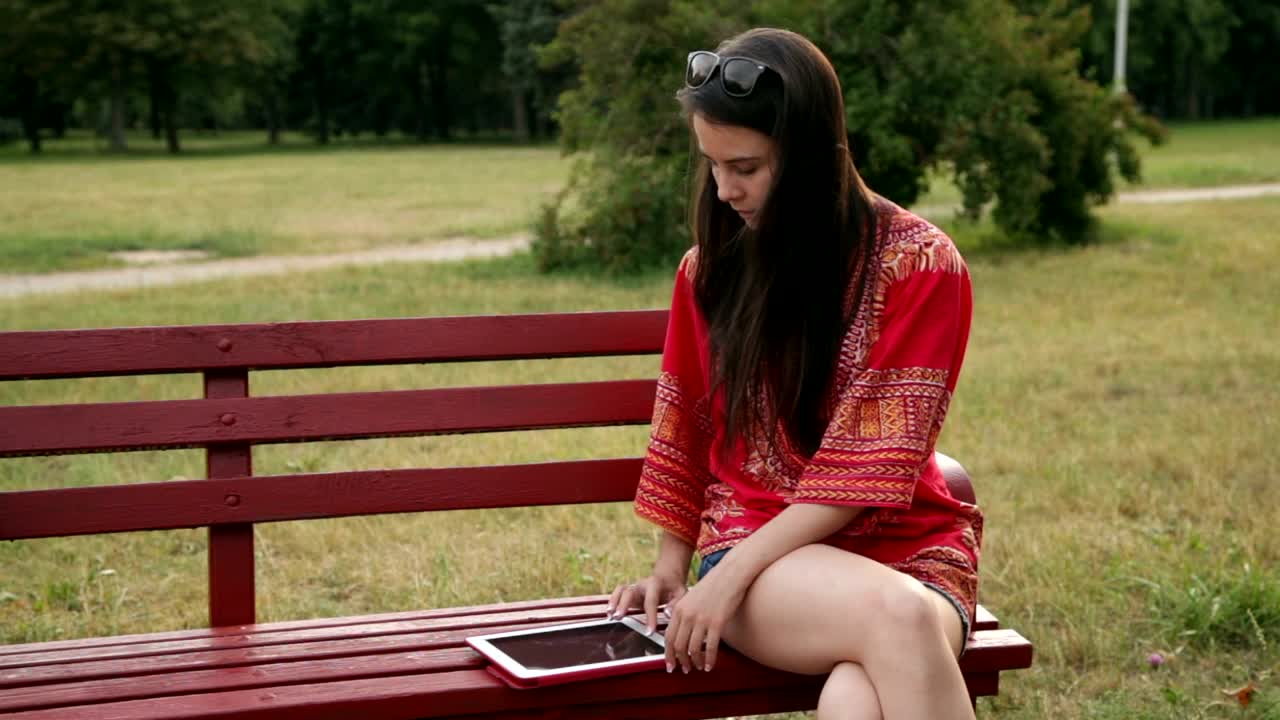 Download Stock Footage Woman Using Her Tablet In The Park Live Wallpaper Free