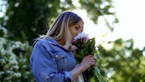 Stock Footage Woman In Denim Jacket Smelling Flowers On Spring Day Live Wallpaper Free
