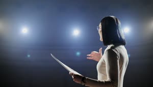 Stock Footage Woman Giving Motivational Talk On Dark Stage With Bright Lights Live Wallpaper Free