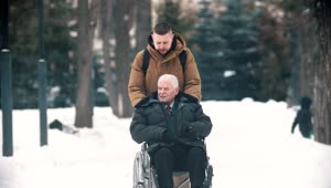 Stock Footage Young Man Walking With Grandfather In A Wheelchair Live Wallpaper Free