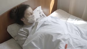 Stock Footage Woman In Face Mask Checks Thermometer While In Bed Live Wallpaper Free