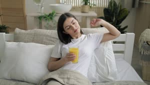 Stock Footage Woman Relaxes In Bed With Juice During Lockdown Live Wallpaper Free