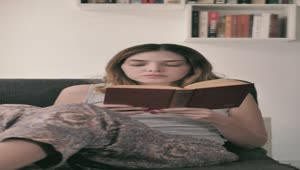 Stock Footage Young Woman Lying On A Sofa Reading A Book Live Wallpaper Free
