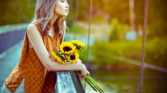 girl standing with sun flowers wallpaper