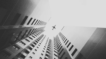 airplane flying above skyscrapers hd wallpaper