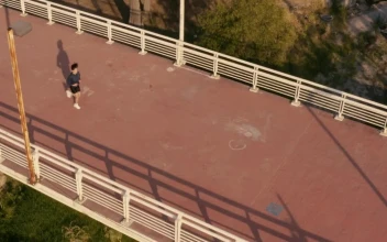Stock Video Aerial Shot Of A Girl Jogging On A Footbridge for PC