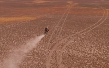 Stock Video Aerial Shot Of A Motorcyclist In The Desert for PC