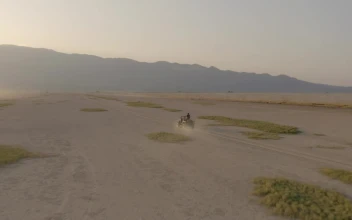 Stock Video Aerial View Of A Jeep Traveling Through A Desert At for PC