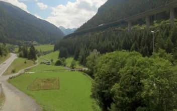 Stock Video Aerial View Of Highway Around Forested Mountain for PC