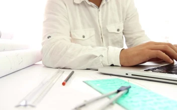 Stock Video Architect Working On Blueprints And His Laptop For PC