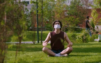 Stock Video A Young Man Wearing A Medical Mask Meditating On The For PC