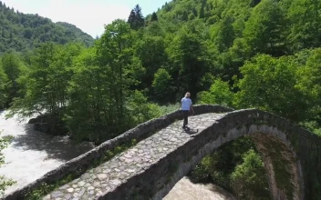 Stock Video A Woman Standing On A Bridge Over A Stream For PC
