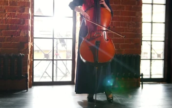 Stock Video A Woman Standing In A Room Playing The Cello For PC