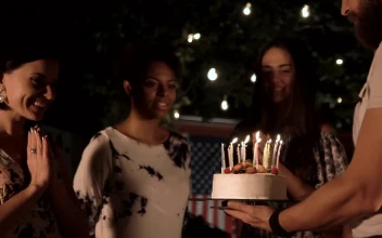 Stock Video A Woman Blows The Candles Of The Birthday Cake For PC