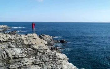Stock Video A Person Taking Pictures Standing On A Cliff For PC