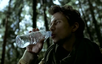 Stock Video A Man Drinks Water From A Bottle In The Woods For PC