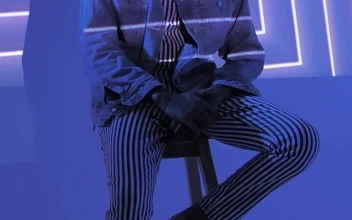 Stock Video A Hipster Sitting On A Chair Under Lights For PC
