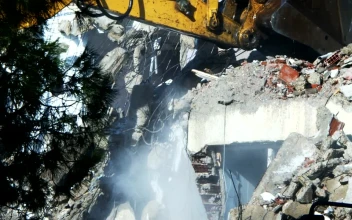 Stock Video Bulldozer Cleaning Debris From A Ruined Building For PC