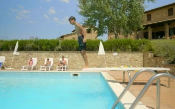 Stock Video Boy Swimming In An Outdoor Pool On A Sunny Day For PC