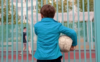 Stock Video Boy Holding Deflated Ball Watching Other Kids Playing Football For PC