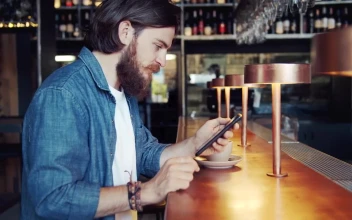 Stock Video Bearded Man Uses Mobile App In Urban Bar For PC