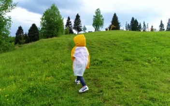 Video Stock Child Taking A Walk In The Grass Wearing A Raincoat For PC