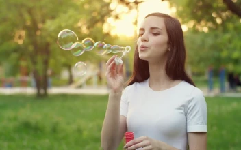 Video Stock Cheerful Girl Blowing Soap Bubbles In A Park For PC