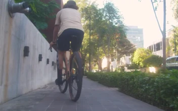 Stock Video Cyclist Zigzagging Down The Sidewalk On The Street For PC