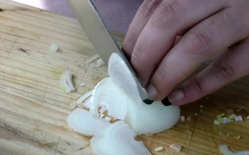 Stock Video Cutting Onion Into Slices On A Board For PC