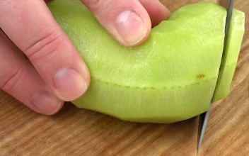 Stock Video Cutting A Kiwi Into Chunks For PC