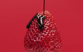 Stock Video Cover A Strawberry With Chocolate Syrup On A Red Background For PC